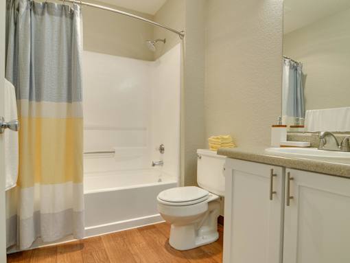A bathroom with a toilet, sink, and shower.