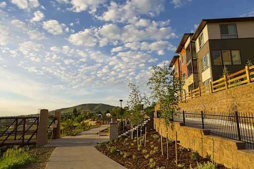 A walkway leads to a building with a mountain in the background.