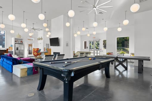 Clubhouse with billiards table, ping pong table and multiple pendant lights