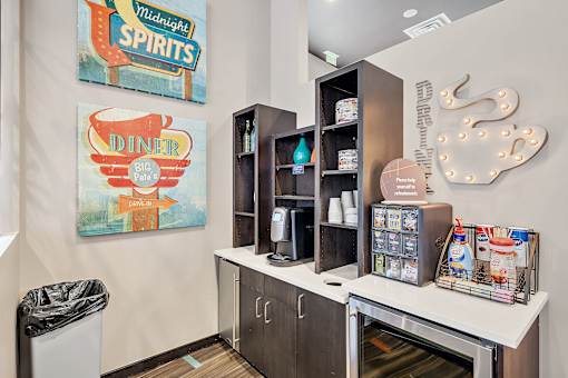 A diner themed room with a trash can and a fridge.