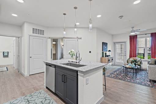 A modern kitchen with a large island and a dining area with a couch.