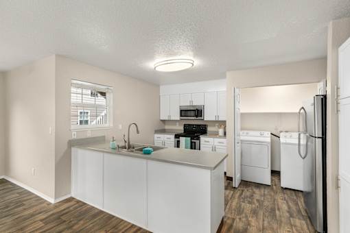 A kitchen with white cabinets and appliances.
