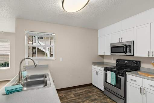 A kitchen with a black stove top oven and white cabinets.