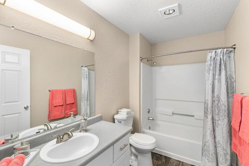 A bathroom with a toilet, sink, and shower.