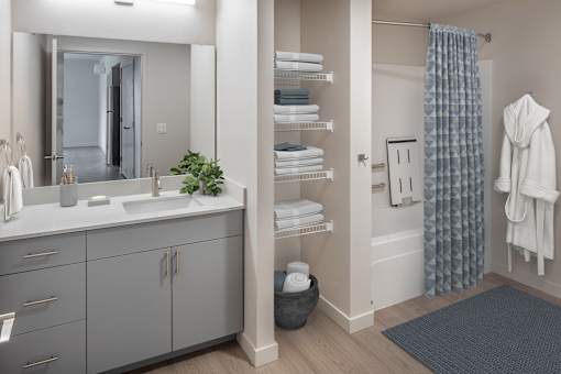 A bathroom with a sink, mirror, and towel rack.