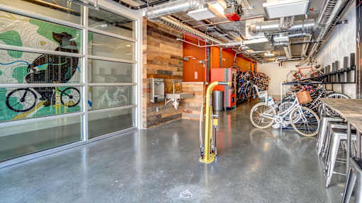 A room with a bicycle rack and a mural on the wall.