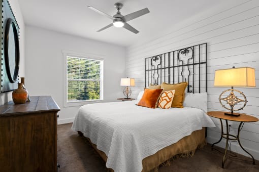 Primary Bedroom with ceiling fan and shiplap accent wall