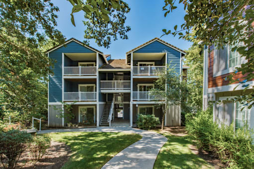 Three story apartment building with balconies and green landscaping at Canyon Creek Apartments, Oregon