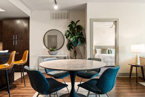 A dining room with a round table and chairs.
