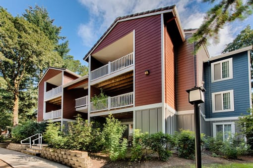 Apartment building with covered balconies and red siding at Canyon Creek Apartments, Oregon, 97070