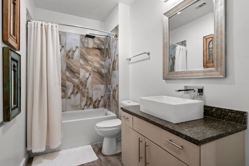 Bathroom with above-counter sink and bath/shower combination