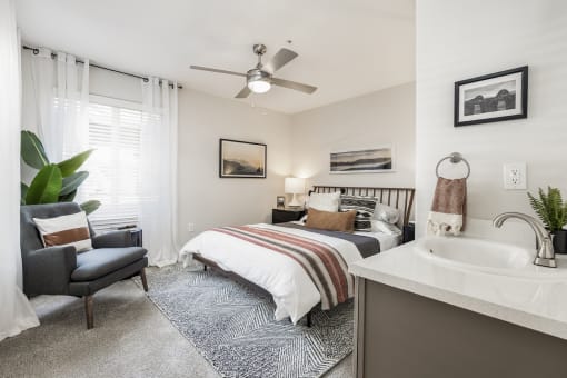 Bedroom with en suite sink and ceiling fan at Canyon Creek Apartments, Wilsonville, OR
