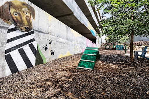 A dog painted on a wall with a striped shirt.