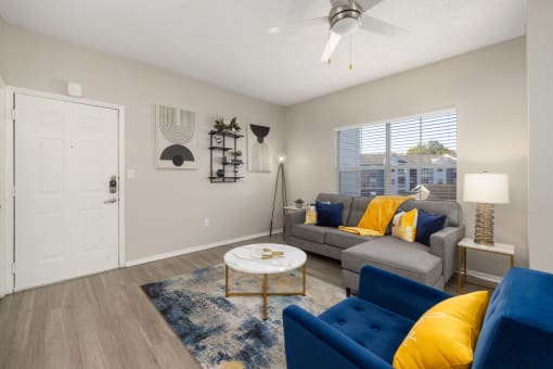 a living room with yellow pillows and blue couches