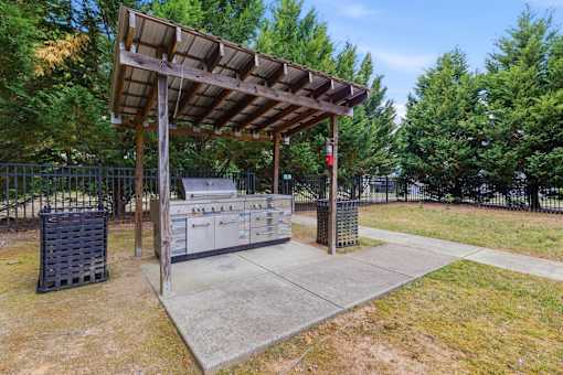 A wooden structure with a metal gate and a signboard in front of a fence.