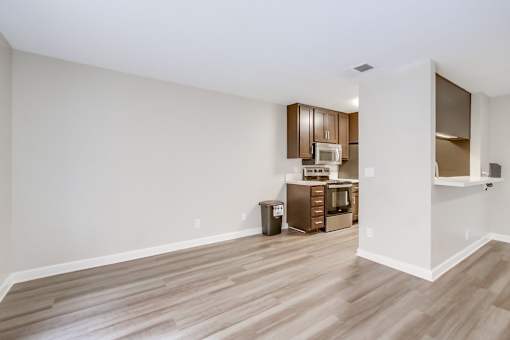 A kitchen area with wooden floors and white walls.