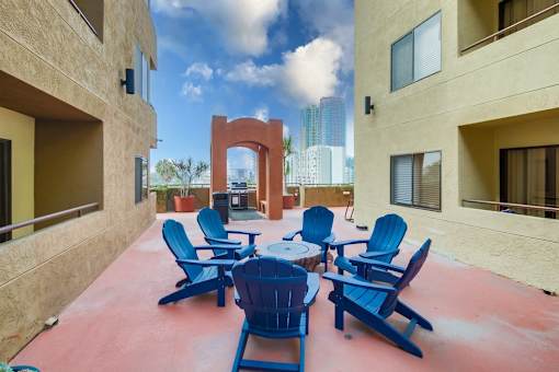 A patio with blue chairs and a table.