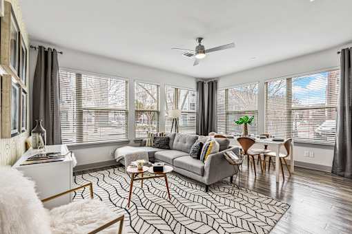 A living room with a grey couch, a coffee table, and a ceiling fan.