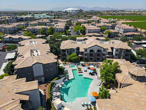 A large swimming pool is surrounded by apartment buildings.