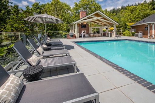 a swimming pool with chaise lounge chairs and umbrellasat Arbor Heights, Tigard, 97224