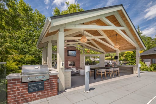 a covered patio with a grill and a table and chairs at Arbor Heights, Tigard, 97224