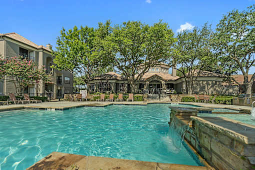 A large swimming pool with a waterfall in the middle of it.
