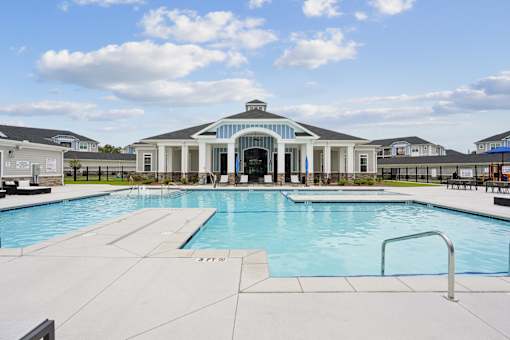 A large swimming pool with a building in the background.