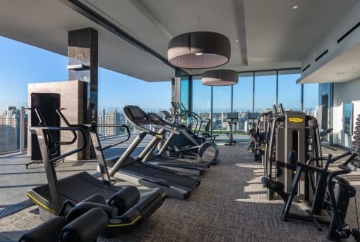 a gym with cardio equipment and a view of the city at Stanza Little Italy, San Diego, CA, 92101