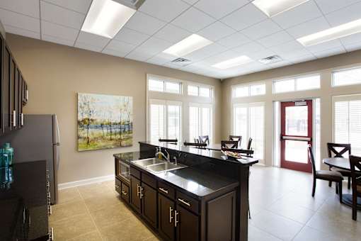 A kitchen with a black counter top and a refrigerator.