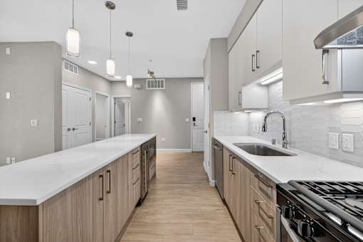 A modern kitchen with wooden cabinets and a white countertop.