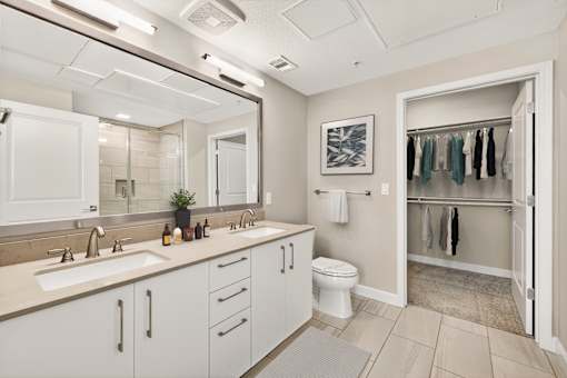 A bathroom with a white toilet and a sink with a mirror above it.