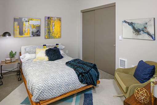 A bedroom with a bed and chair
