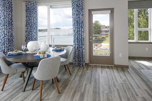 A dining room with a table and a view of the water.