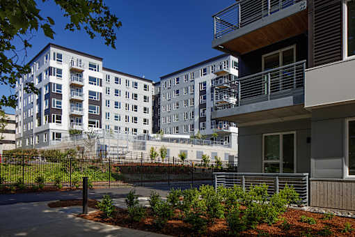 A modern apartment complex with a fenced courtyard.