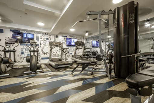 a gym with exercise machines and a wall covered motivational words wall-paper