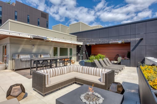 a patio with couches and tables and a fire pit
