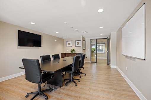 A conference room with a long table and chairs.