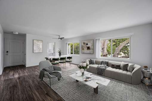 A modern living room with a grey sofa, a grey armchair, a coffee table, and a rug at Hillsdale Garden Apartments, San Mateo, CA 94403