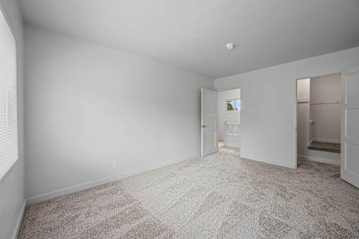 A large empty room with a carpeted floor and a doorway leading to another room at Hillsdale Garden Apartments, San Mateo