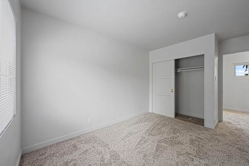 A room with a carpeted floor and a closet with a door at Hillsdale Garden Apartments, 94403