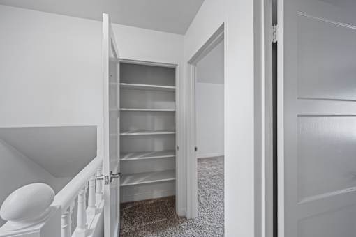 A white hallway with a white staircase and a white door at Hillsdale Garden Apartments, San Mateo