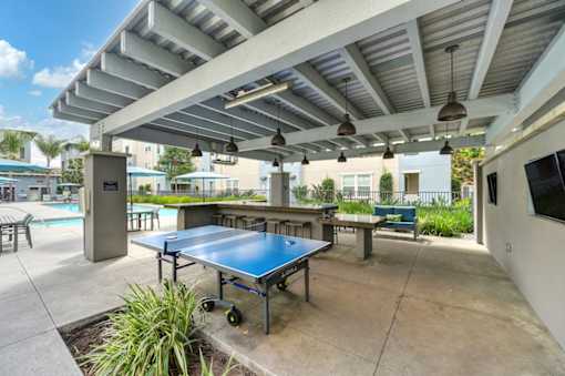 A blue table tennis table is in the middle of a patio.