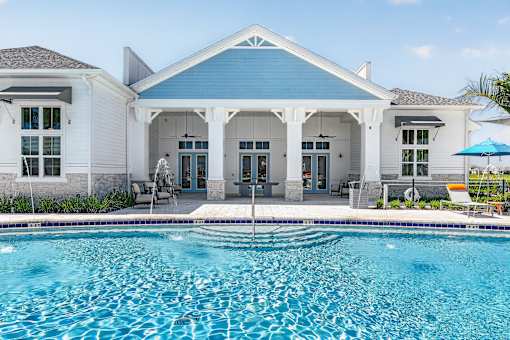 A white house with a pool in front.