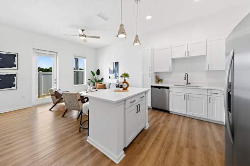 A kitchen with a white island and wooden floors.