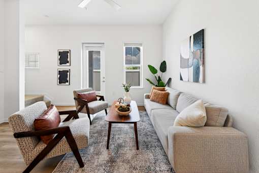 A living room with a couch, chairs, and a coffee table.