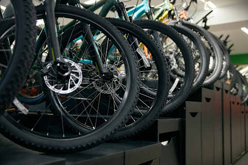 A row of bicycles are lined up on a shelf.