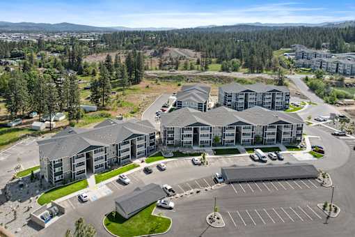 A large building complex with a parking lot in front.