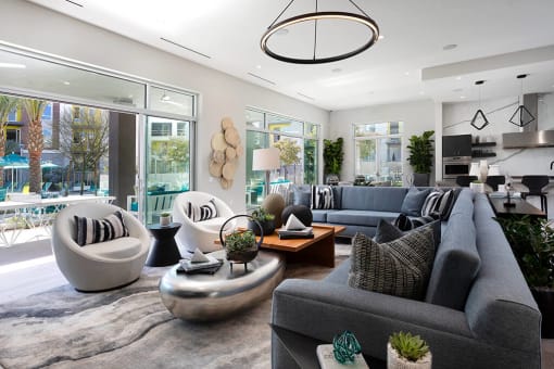 Clubroom with ample seating at Rivue apartments in Chula Vista San Diego with open glass doors leading to the pool deck.