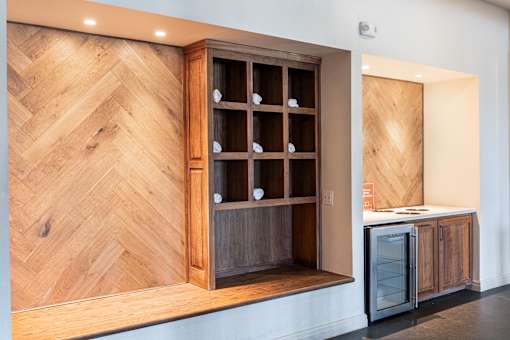A wooden cabinet with glass doors is open, revealing a kitchen appliance inside.