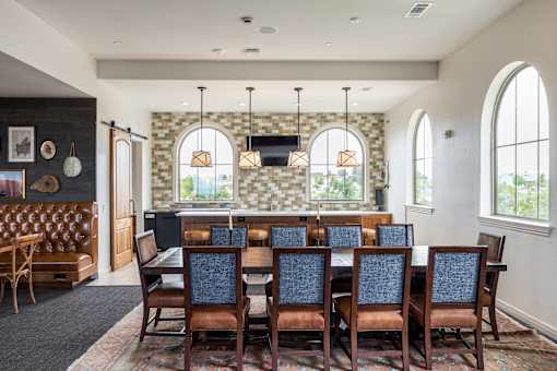 A dining room with a large table and chairs.